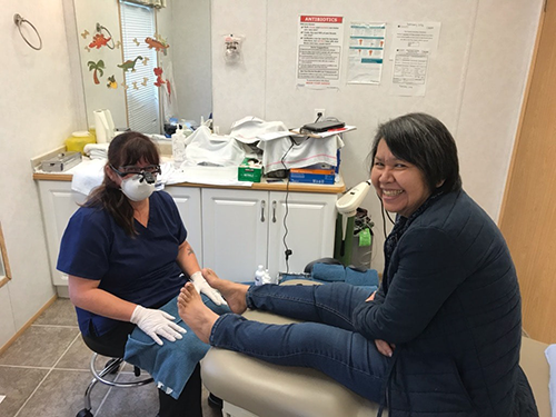 nail technician performing nail bracing on toenails